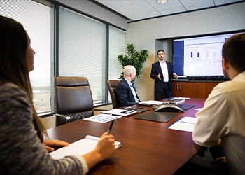 Group of team members and clients meeting in a conference room