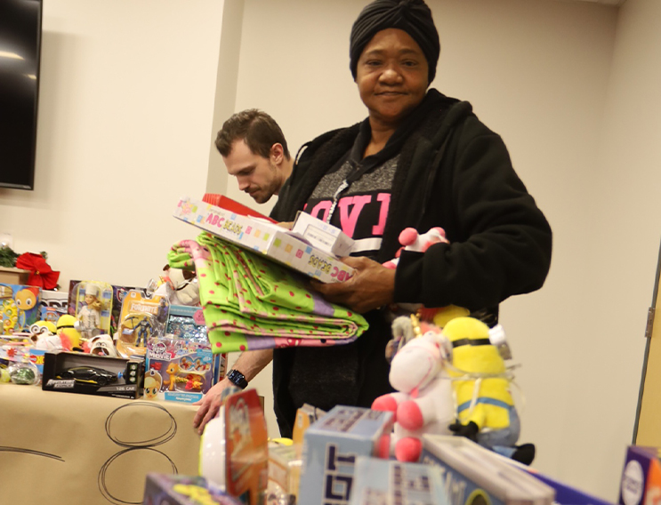 Volunteer holding a board game prior to gift wrapping