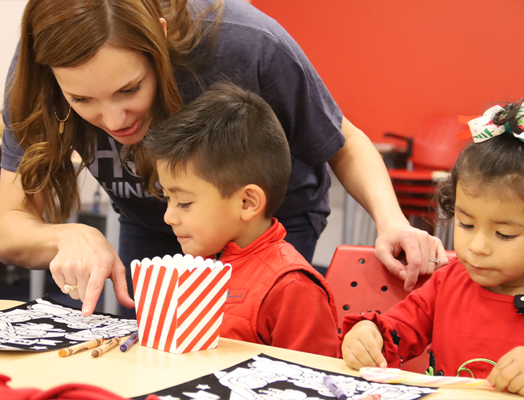 Volunteers helping kids with their coloring sheets