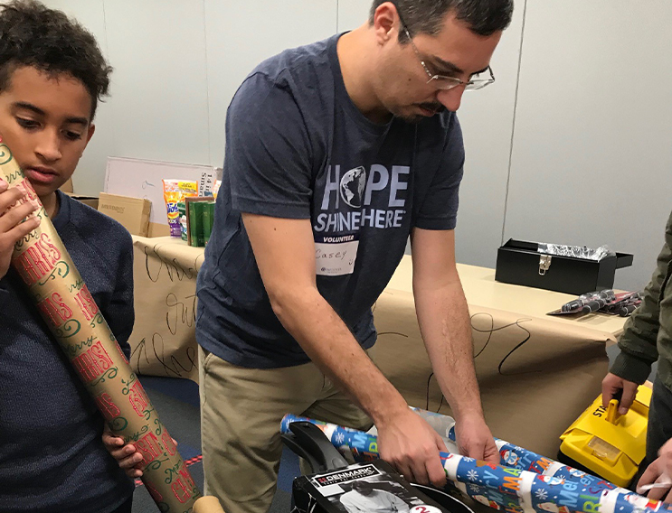 Team member and young volunteer picking out wrapping paper