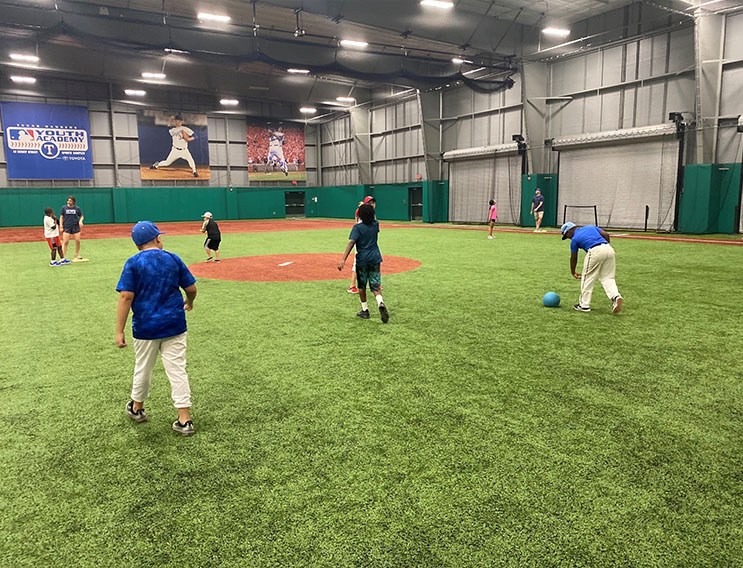 Team members and young people playing baseball