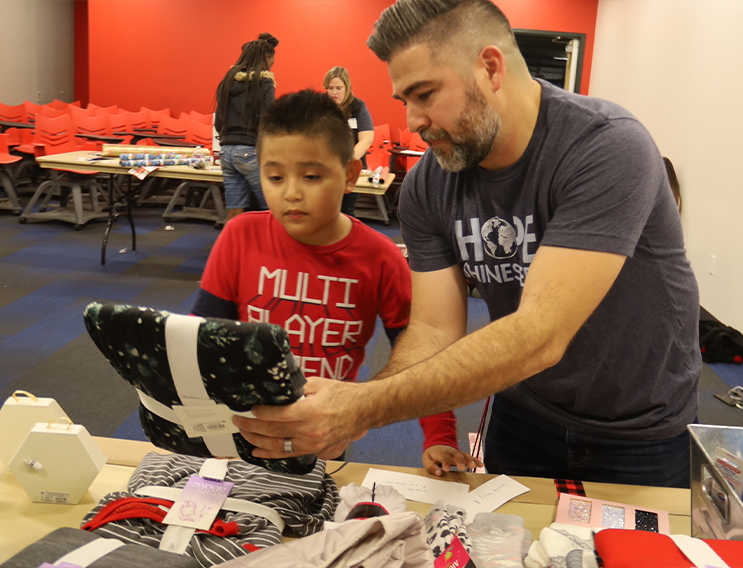 Team member showing child a set of pajamas