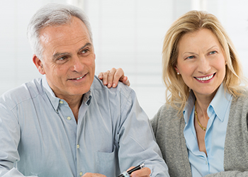 Older man and woman smiling during retirement planning meeting